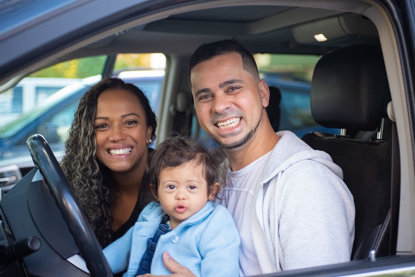 Parents sharing a happy moment with their child in the car